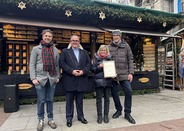 Prämiert als schönste Bude 2024: Münchner Licht auf dem Münchner Christkindlmarkt erhielt eine Urkunde von Wirtschaftsreferent Clemens Baumgärtner  